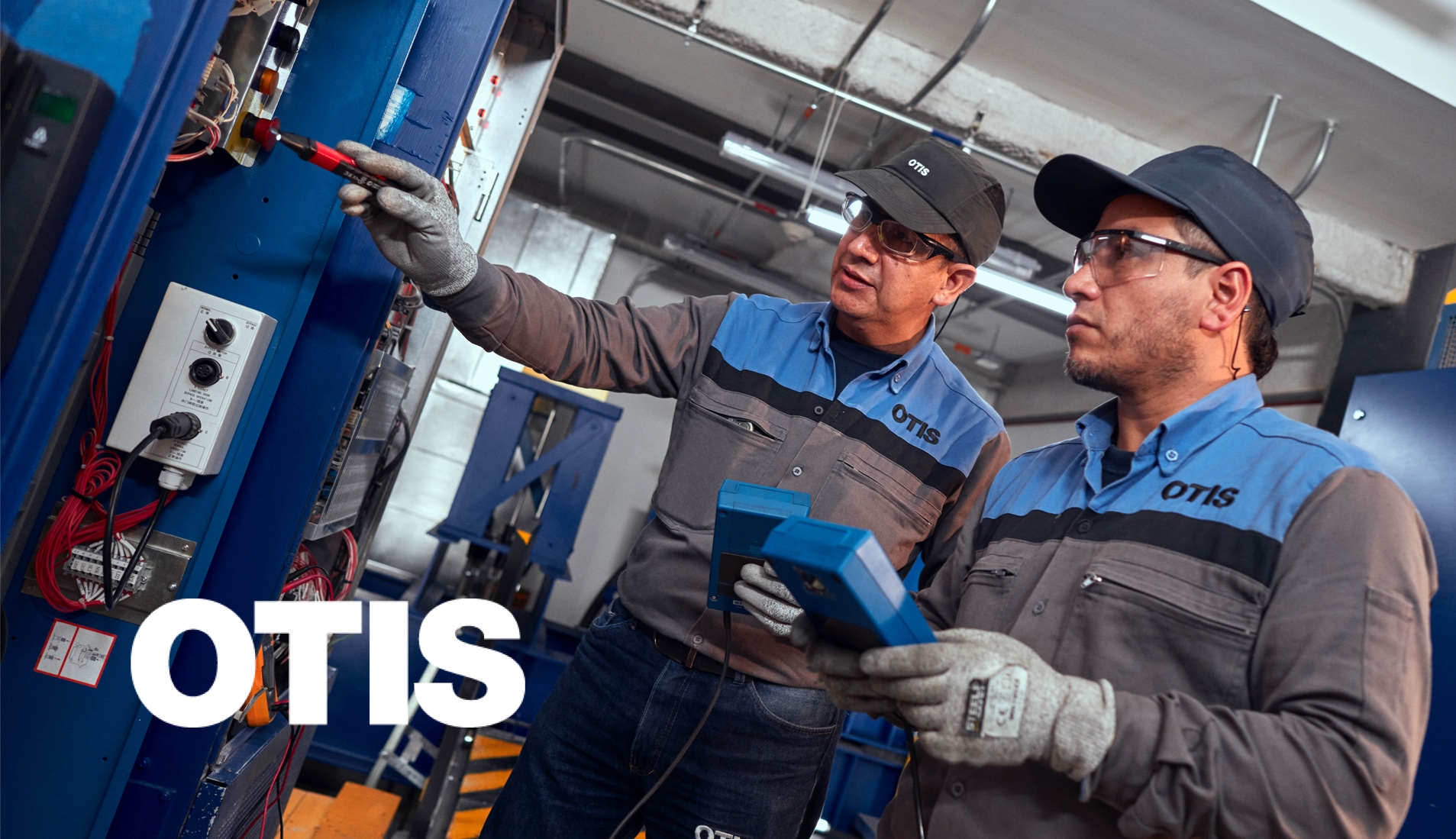 Two Otis elevator mechanics working
